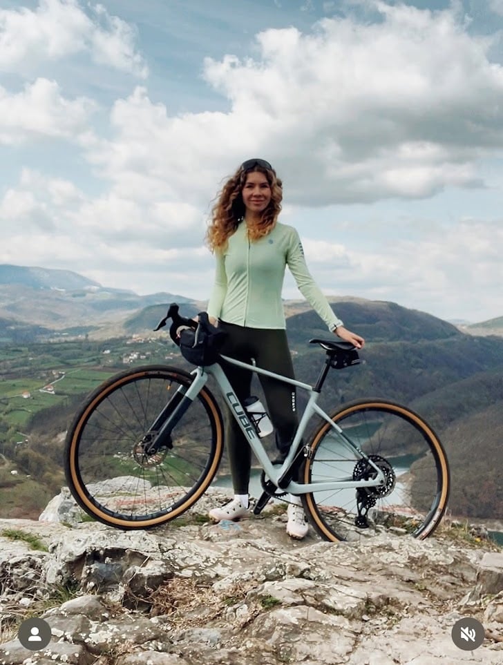 Diana Tuchs with her gravel bike on a mountain top